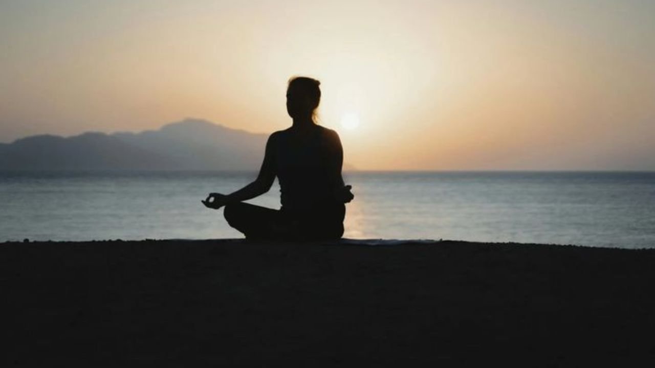 A peaceful person sitting quietly in nature, reflecting signs of stress and the need for mindfulness and presence.