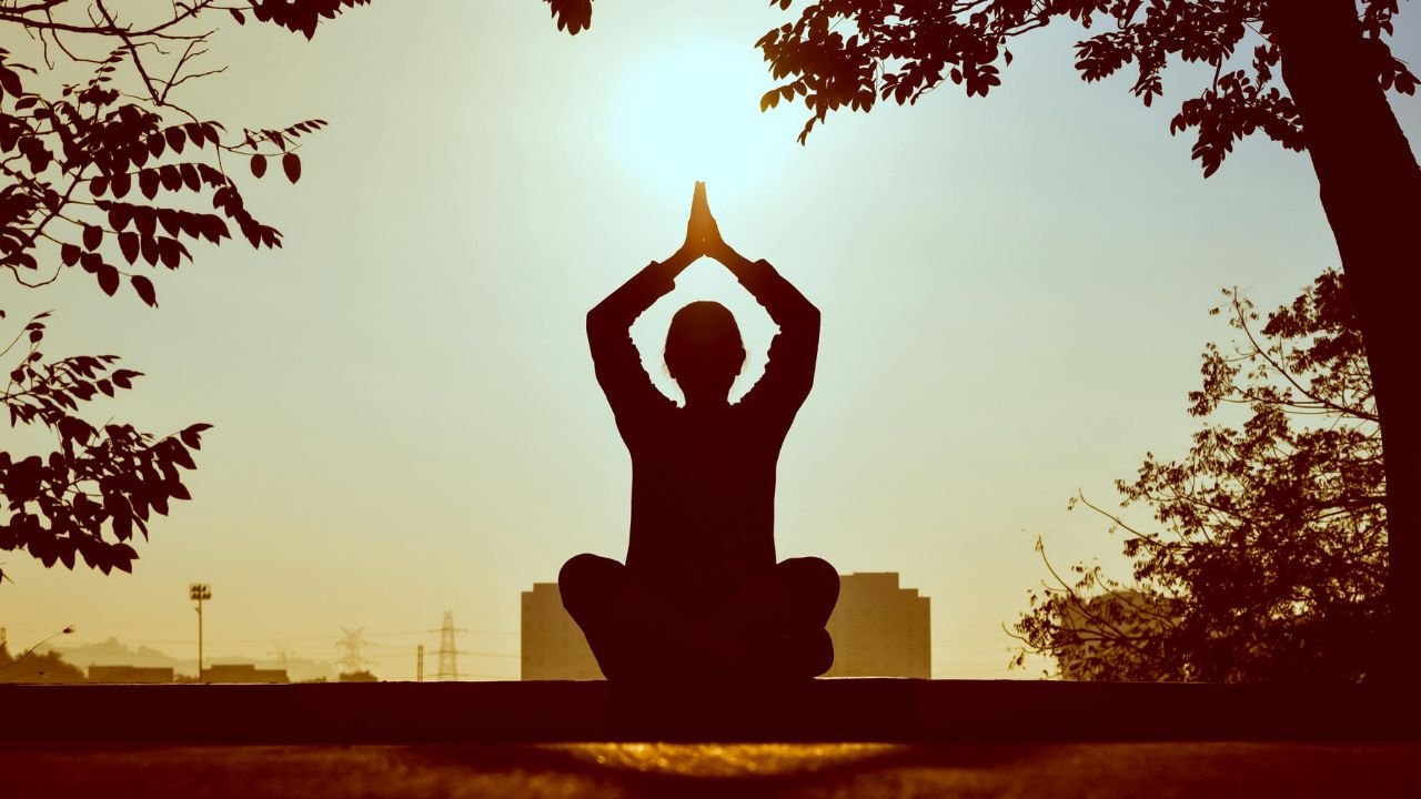 A peaceful person meditating in a quiet space with eyes closed, practicing a short 5-minute mindfulness session recommended by experienced meditation practitioners.