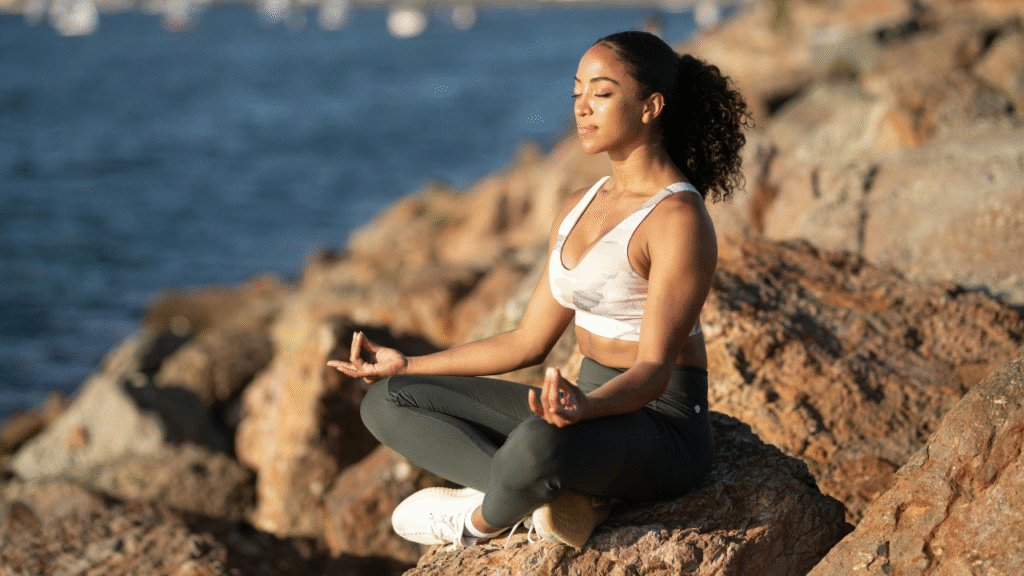 "Person taking a deep breath outdoors, using mindful breathing to relax and calm the mind."